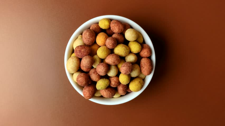 Food, nuts coated with salt and paprika, peanuts as a source of protein. Salted peanuts coated with paprika as a food background for your design