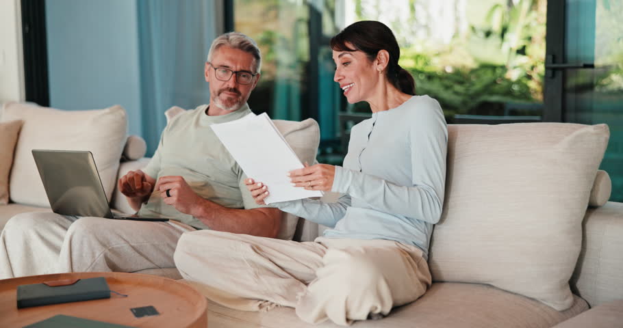 Couple, documents or laptop with high five on sofa for financial success or investment in home. Mature, man and woman with smile or papers on computer for finance, budget planning or winning in house