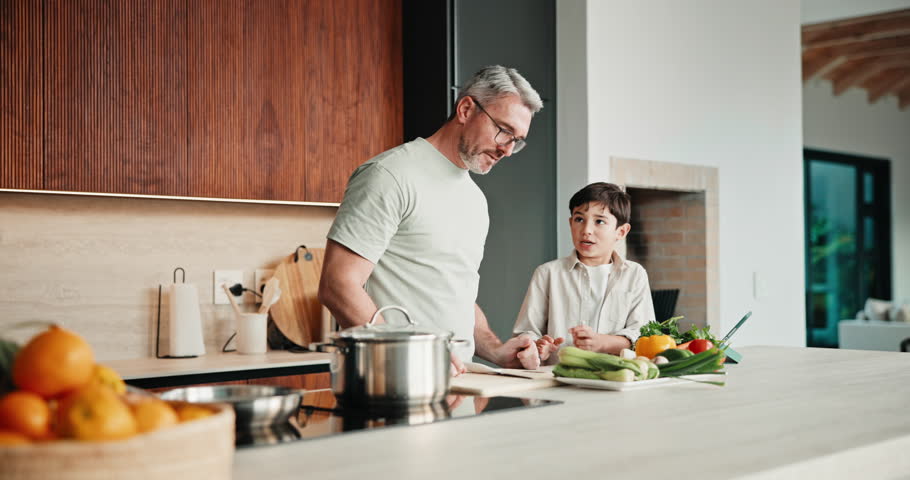 Cooking, learning and dad with child with vegetables for meal prep, lunch and recipe in kitchen. Family, teaching and father with boy with ingredients for healthy diet, nutrition and bonding in home