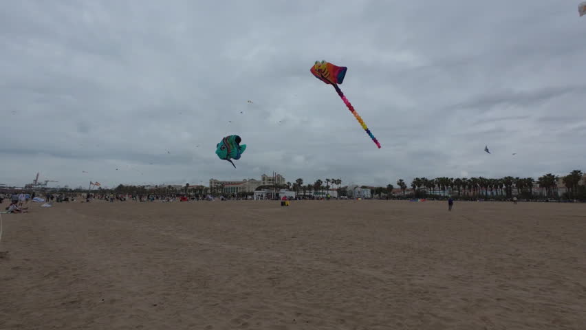 Large decorative show kites hovering over beach spectators - Valencia, Spain (4K)