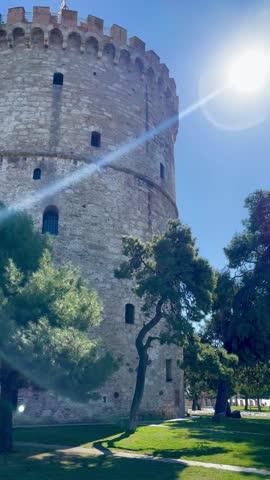 Bright summer sun shining above historic architecture and blue sky in Thessaloniki, Greece. Scenic Mediterranean city atmosphere with warm sunlight and travel destination vibes.