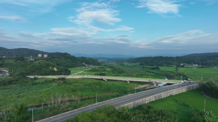 Scenic aerial view of concrete bridge crossing rural river.