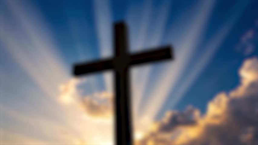 holy sunlight shining on the Christ wooden cross symbol with religious clouds on blue sky background