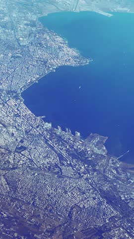Stunning plane pov aerial shot of Thessaloniki in Greece, sprawling city nestled around a picturesque bay, vertical video