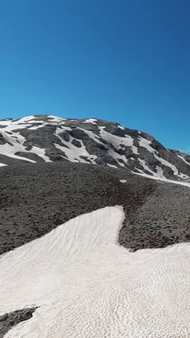 Snowy mountain landscape. on top of the mountain. Snow-covered mountain road, high snowdrifts on the sides. High quality 4k footage
