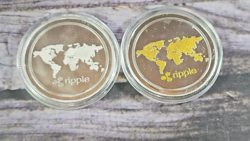 Silver and golden Physical Ripple XRP,  the native cryptocurrency of the XRP Ledger (XRPL), an open-source, decentralized blockchain technology, designed to facilitate fast cross-border payments
