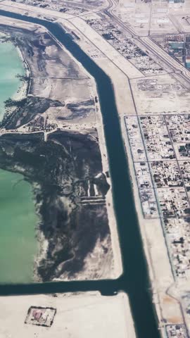 Aerial view of Abu Dhabi coastline with green waters and adjacent infrastructure in UAE