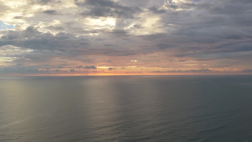 Aerial view of a stunning sunset over the ocean, with the sun