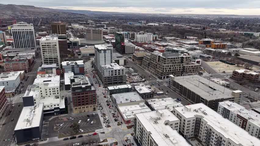Sweeping aerial drone footage of downtown Boise, Idaho under overcast winter skies showcases the city