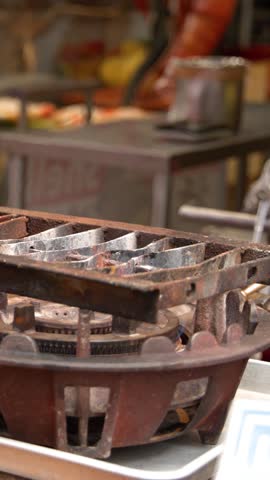 Close-up shot of fresh oysters grilling on a gas burner at a Tokyo market