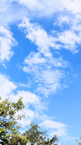 Beautiful blue sky with fluffy white clouds moving in time lapse on a bright sunny day, perfect background for creative projects.