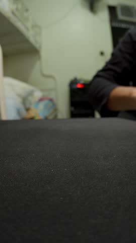 Vertical close-up shot of a person using a white computer mouse on a black mousepad in an office setup in London. Ideal for technology, gaming, office work, and digital business marketing