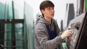 Young guy worker in uniform operates machine control panel in factory  - Powered by Shutterstock - Get 15% off with code: PIKWIZARD15
