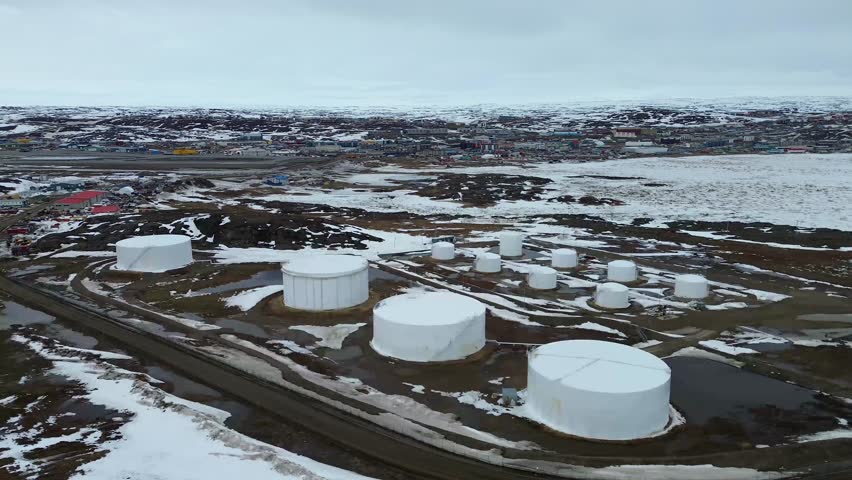 High-angle drone overview of the primary bulk fuel storage facility and road infrastructure in Iqaluit, Nunavut.