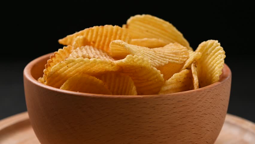 Potato Chips Rotating in Bowl on black background