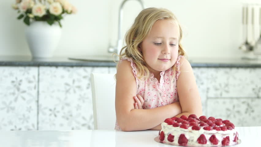 Girl admires cake and smiling

