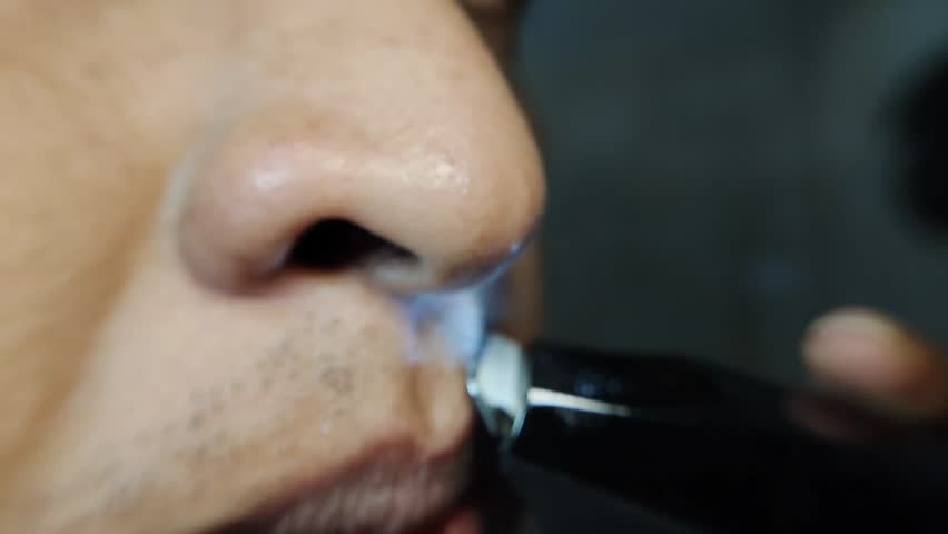 close up of a man shaving his moustache with an electric shaver
