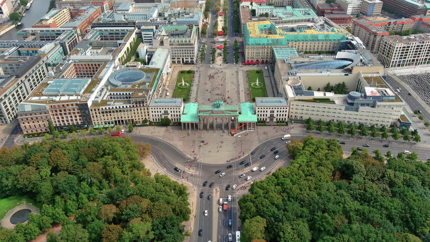 4K aerial view of Brandenburg Gate from the Tiergarten side with quadriga statue, Pariser Platz square, Hotel Adlon and Unter den Linden boulevard in central Berlin.