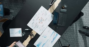 Top Down View of Diverse Business Team Gathered Around Meeting Table With Laptops and Statistical Reports. Visualization Icons Represent Connectivity, Cloud Security. Action Zoom out camera. - Powered by Shutterstock - Get 15% off with code: PIKWIZARD15
