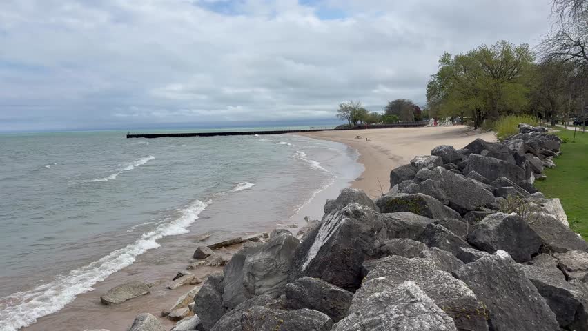 4K horizontal video of a sandy beach in Chicago with a lighthouse, Lake Michigan waves, and a peaceful shoreline landscape