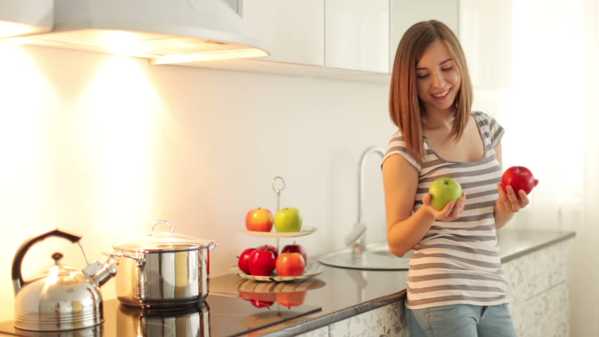 Girl holding two apples in her hands and smiling
