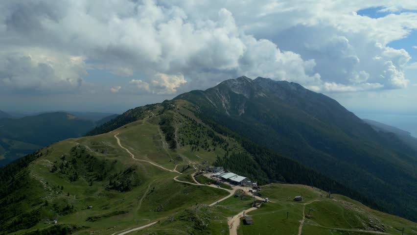 Aerial view of hiking trails and mountain refuge on Monte Baldo under dramatic clouds