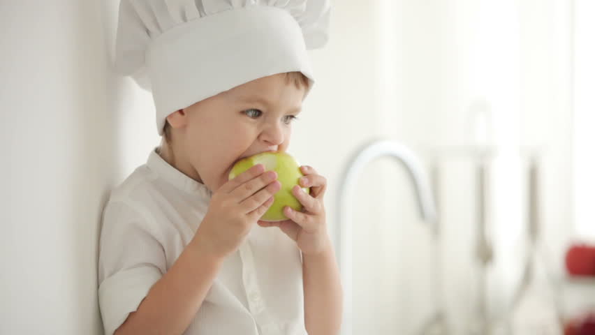 Boy eating apple with great pleasure
