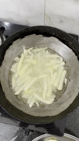 Vertical Slow Motion Crispy French Fries Frying in Hot Oil. Zoom in