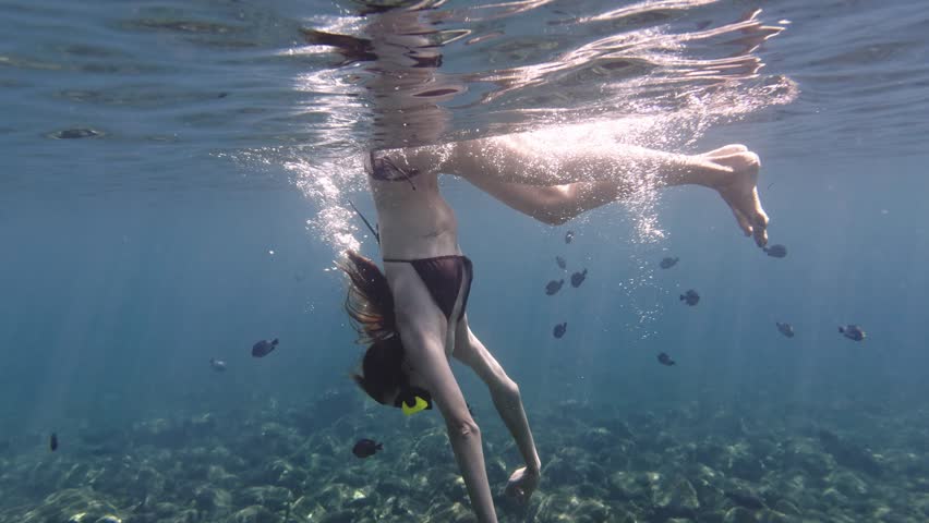 Woman diving and snorkeling underwater in tropical sea