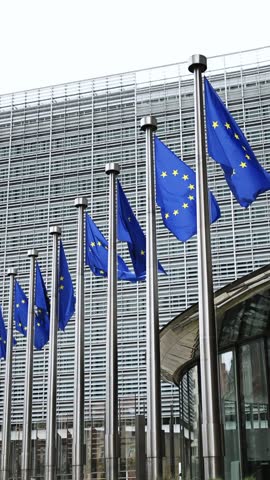 Eu Flags Waving Against The European Commission Headquarters Background In Brussels Belgium Vertical Video