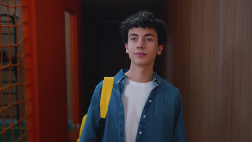 Caucasian happy student guy school boy walking in sport hall university college man smiling positive pupil male teen schoolboy teenager corridor walk go education studying going to class lesson smile