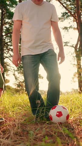 Children son daughter, play football with dad on lawn. Parent father, kids boy girl run red ball in park. Active, happy family. Family team sports. Dad child play happily with ball on grass in park