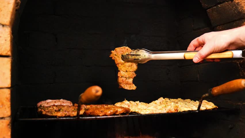 Meat for the Grill. Appetizing, delicious Barbecue and Grill . Pork Steaks, Sausages, and Chicken Breasts on the Grates.Hands turn the meat on the grate in an outdoor oven. footage