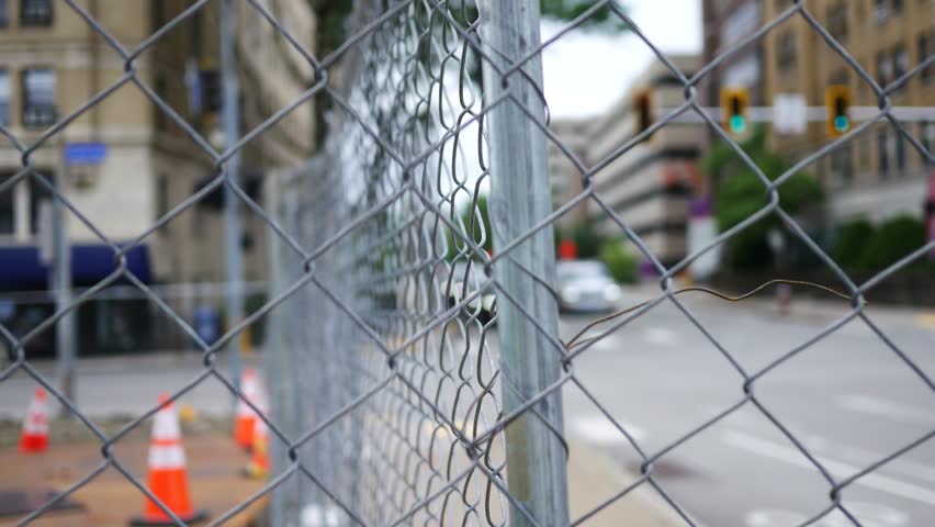 Timelapse of City Traffic Through Chain Link Fence
