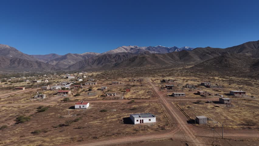 Scenic aerial view of a remote mountain settlement in a vast rural landscape.