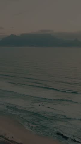Cinematic Foggy Sea Coast with Rolling Waves and Mountain Silhouette at Dusk