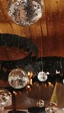 Vertical video. Hanging disco mirror balls with warm decorative lights for party decor and event setup. Close-up reflections and glowing bokeh inside indoor celebration space. - Powered by Shutterstock - Get 15% off with code: PIKWIZARD15