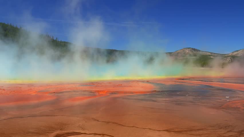 Grand Prismatic Spring vibrant colorful orange hot springs pool Midway Boardwalk trail Mid Geyser Basin Wyoming USA Yellowstone National Park nature landscape Opal Pool sunny morning blue sky pan