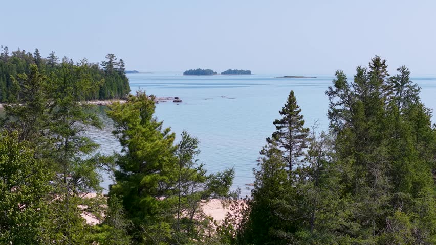 An aerial drone shot of a serene wilderness area in Hessel, Michigan, featuring Lake Huron