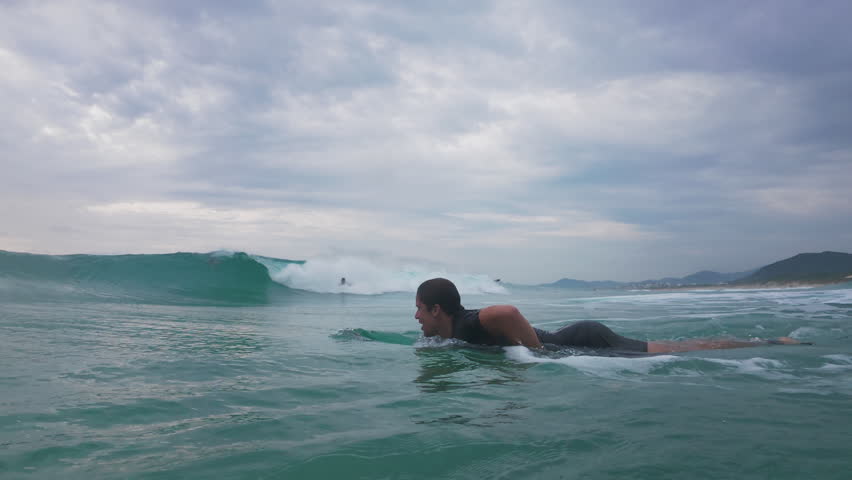 Surfer dives under the wave. Underwater footage of the surfer diving under the wave with surfing board