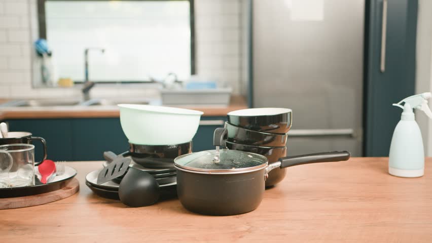 Messy Kitchen Counter Piled With Dirty Dishes and Cooking Utensils, Awaiting Household Chores