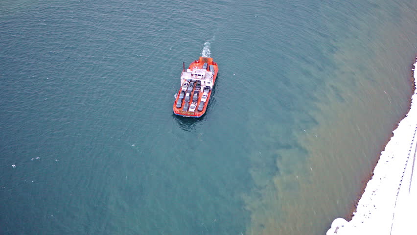 Drone shot of a transport ferry moving people and automobiles across the river to Sugar Island.
