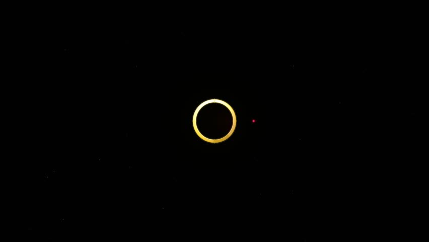 Close-up time-lapse of a solar eclipse showing the bright ring of fire and glowing corona against a black night sky.