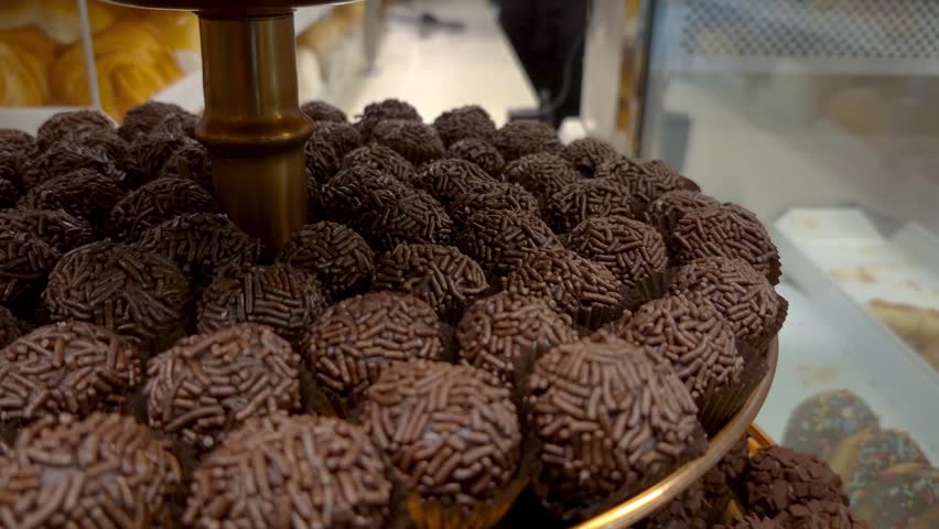 Closeup of chocolate fudge balls with sprinkles in a bakery window_mini crane shot.