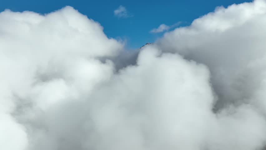 Aerial shot of the clouds and the rugged terrain of the Wasatch Mountains near Salt Lake City, Utah.