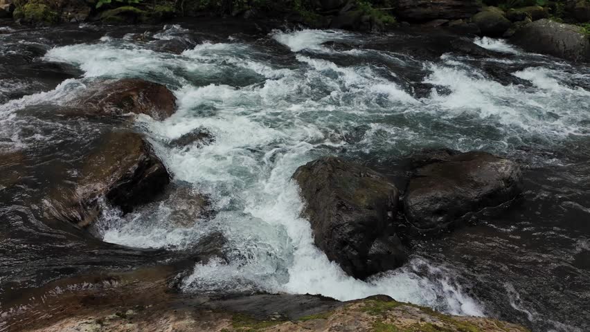 Fast Mountain River Rapids Flowing Between Rocks. Powerful Wilderness Water Stream.