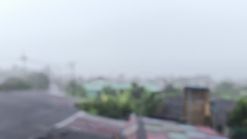 Blurred rain is falling on the roof of village, rural Chiangmai Thailand.