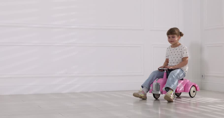 Little child driving toy car at home