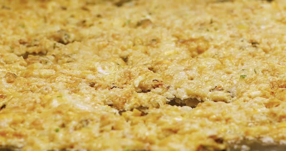 Oyster omelet cooking on a hot pan with metal spatulas. Delicious street food, live cooking, and tasty seafood meal preparation, close-up