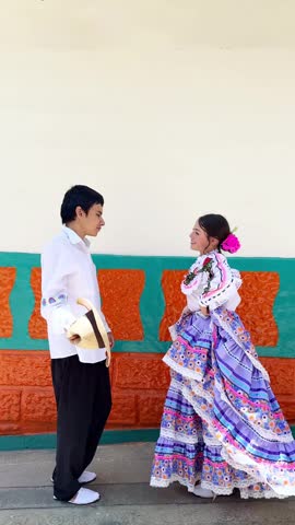 Latin American couple performing traditional folk dance in regional costumes 